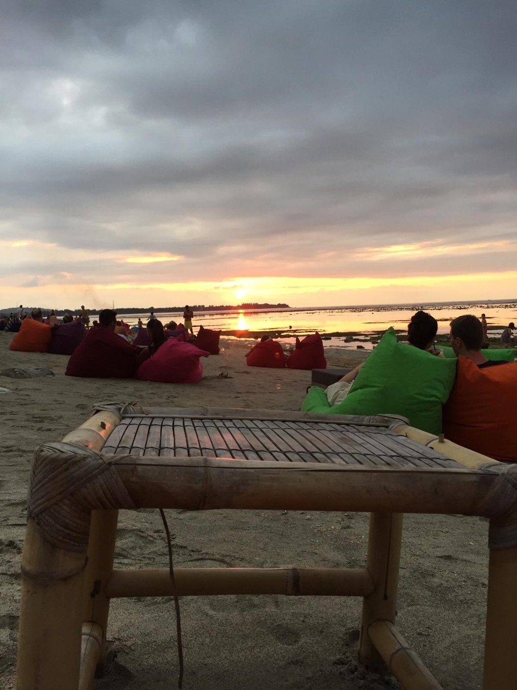 Coucher de soleil sur la plage, installés sur des poufs colorés