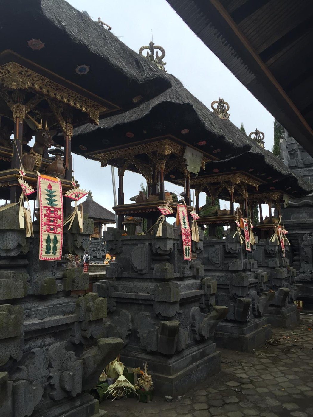 Les toits de chaume noir d'un grand temple balinais, décorés d'offrandes
