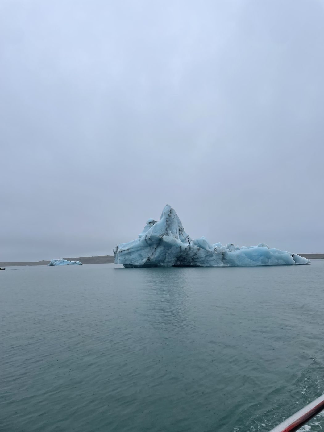 Un iceberg bleuté sur le lagon glaciaire, vu depuis le bateau