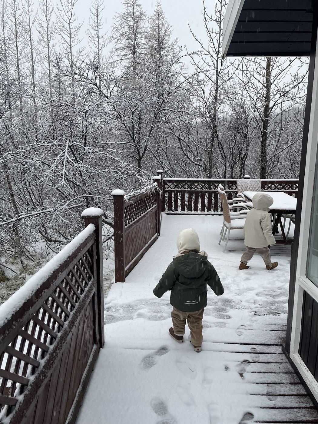 Nos enfants qui découvrent la neige sur la terrasse du chalet