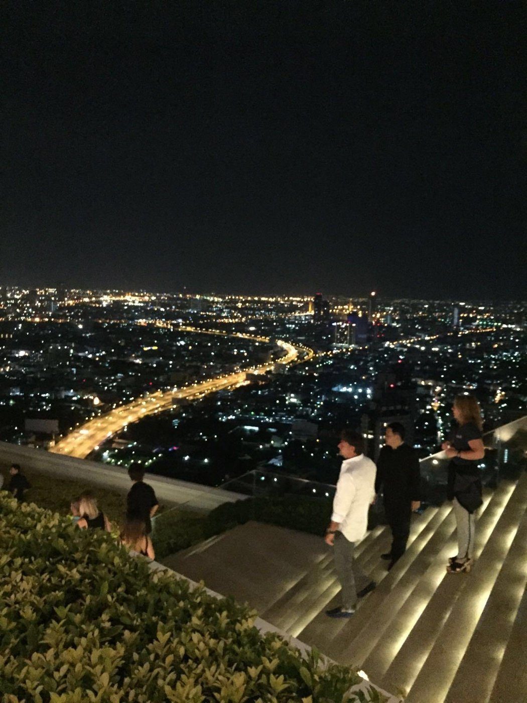 Bangkok de nuit depuis un toit-terrasse, la ville illuminée